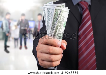 Businessman hand gripping money, US dollar (USD) bills - investment, business concepts