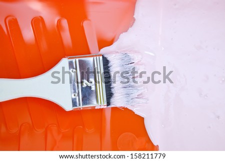 Close-up of a paint  brush in pink paint.