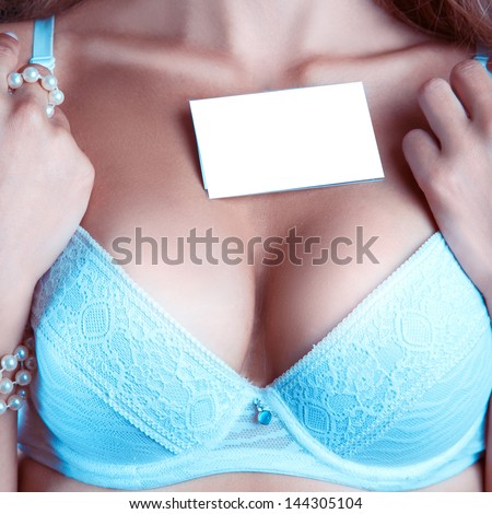 woman\'s breast in a bra with empty name tag in studio