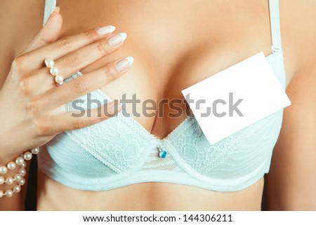 Female boobs in bra with empty name tag in studio