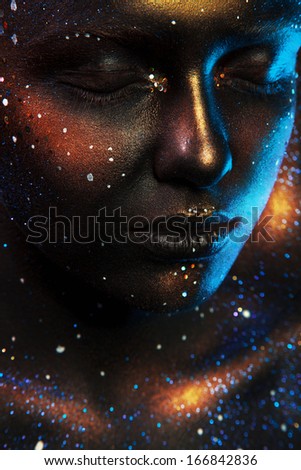 Woman with closed eyes and dark face art in studio