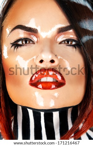 Brunette with wet face looking at camera in studio
