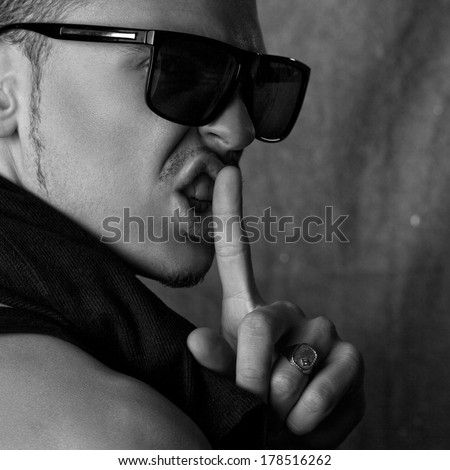 square black and white photo of glamour male in sunglasses in studio