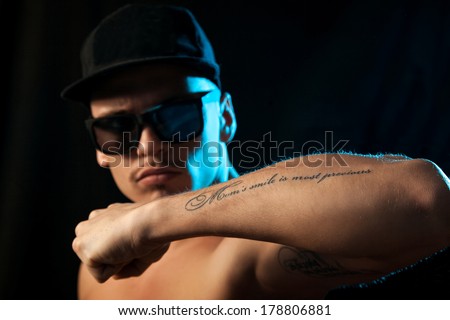 nice man with tattoo on hand in studio on black background