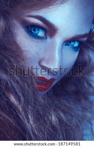 Cold tones portrait of cutie woman with freckles in studio