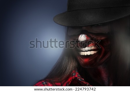 Woman in hat with scary face art for halloween night looking away in studio