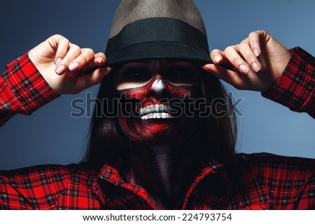 Caucasian woman with scary halloween face art looking at camera in studio