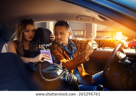 man talking to a young woman in a car with a bag full of money EUR. Inside photo