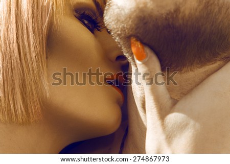 Beautiful blonde woman kissing her boyfriend in neck outdoors