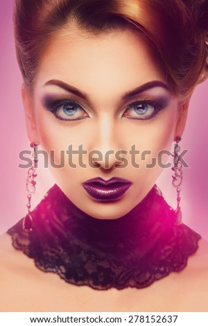 Serious high society person looking at camera with color make up
