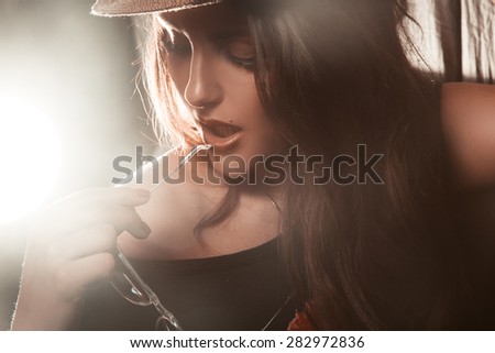 Portrait of adorable young woman in studio with sunglasses in hand. horizontal photo