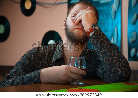 horizontal Photo of Drunk man with a glass of brandy at the bar. horizontal photo