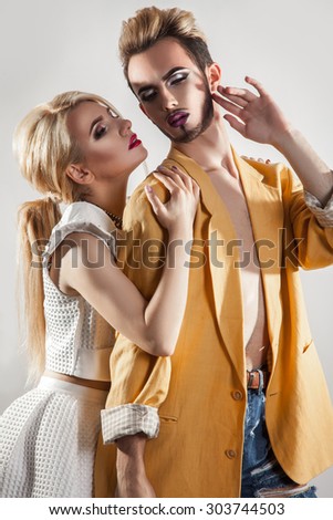 Stylish couple in love. Both with makeup. Vertical photo. Studio shot. Vertical.