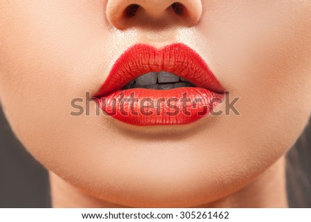Nice close up woman lips with red lipstick in studio