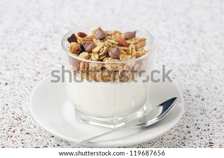 Yogurt with muesli and chocolate drops in a glass beaker of portion