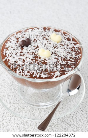 chocolate mousse in a glass sundae dish with chocolate hearts decorated with coconut on a white background