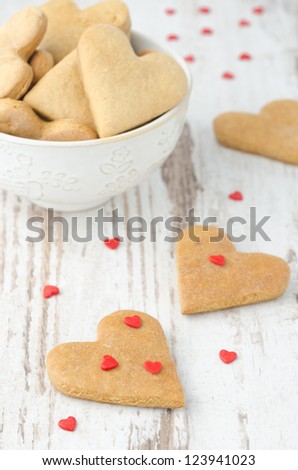 cookies in the shape of a heart on the table and scattered sugar hearts
