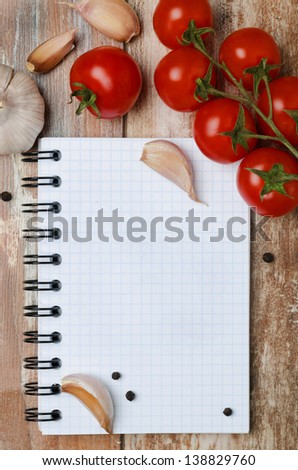 Fresh tomatoes and spices on a wooden background paper for notes (with space for text), vertical, top view