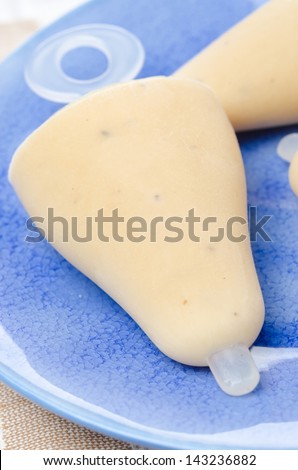 ice cream on a stick with Earl Grey tea on the blue plate close-up
