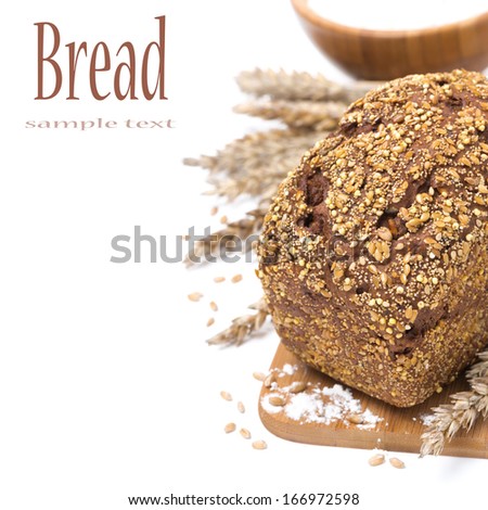 whole grain bread with seeds and a bowl of flour, isolated on white