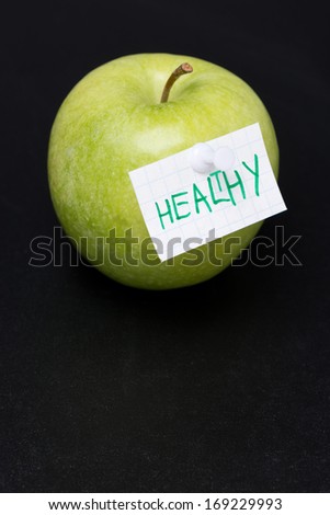 green apple with label on a dark background, close-up