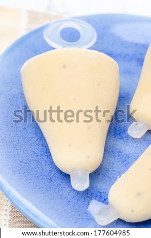 close-up of ice cream on a stick with Earl Grey tea on the blue plate