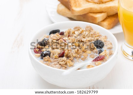 muesli with milk and dried fruit, toast with peanut butter and juice for breakfast, close-up