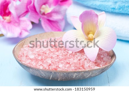 pink sea salt, flowers and towels, close-up
