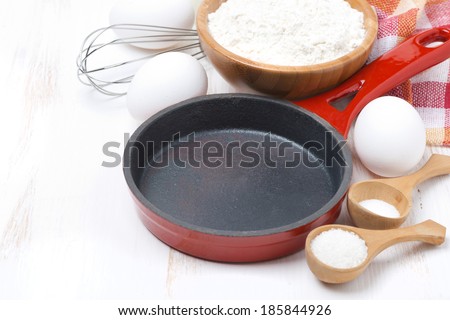 ingredients for a batch of pancakes on white wooden table, horizontal, close-up