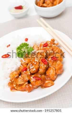 chicken fillet in tomato sauce with sesame seeds and rice, vertical close-up