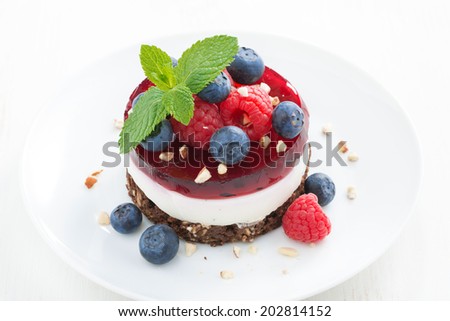 delicious cake with fruit jelly and fresh berries on a white plate, top view, horizontal, close-up