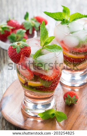 refreshing strawberry and citrus lemonade with mint in glasses, vertical, top view