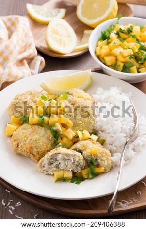 fish cakes with mango salsa and white rice, vertical