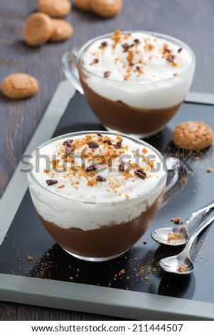 dessert with chocolate, cream and amaretti in cups, top view, vertical