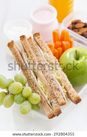 school lunch with sandwich on white wooden table, vertical, close-up