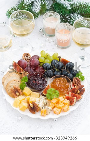 delicious cheese and fruit plate to the holiday on table, top view, vertical
