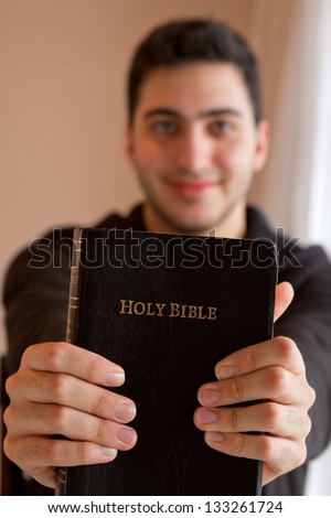 Young man proudly showing his Bible