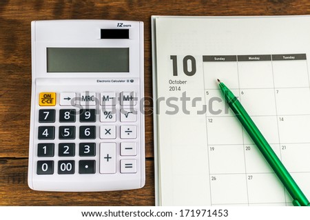 October organizer with calculator & pen: concept for monthly budget.