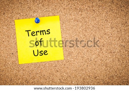 sticky note with word terms of use on corkboard, business concept