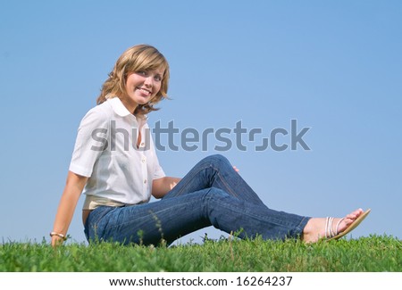 A beautiful lady sitting on the grass in sunny day