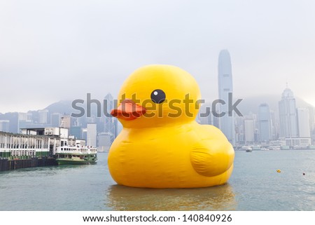 HONG KONG - MAY 6: Giant \'Rubber Duck\' sculpture by artist Florentijn Hofman swims in Victoria Harbour in Hong Kong on May 6 2013. Many local residents are drawn to the attraction.