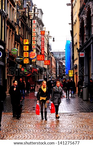 AMSTERDAM, NETHERLANDS-APRIL 11: Shoppers brave the cold rain to shop, eat and enjoy the city of Amsterdam on April 11, 2013. Amsterdam is considered the cultural center of the Netherlands.