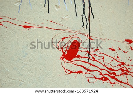 Red color splashed on white textured wall. Dripping paint abstract background.