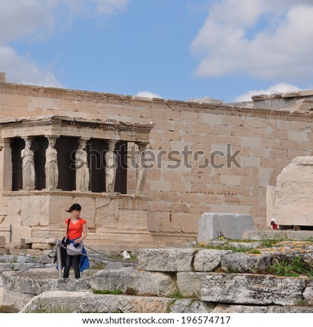 ATHENS, GREECE - MAY 6, 2014: Woman in front of the Porch of Caryatids. Erechtheion ancient temple ruins at the Acropolis of Athens, Greece.