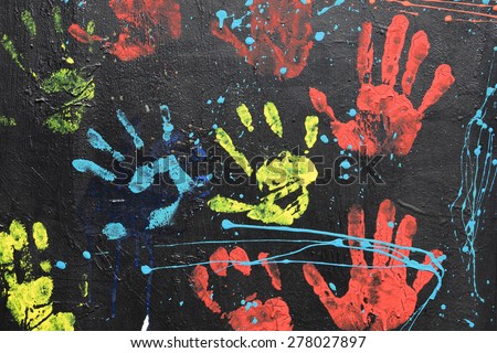 ATHENS, GREECE - APRIL 27, 2015: Messy handprints and dripping paint on textured wall background. Colorful hand imprints abstract graffiti pattern.