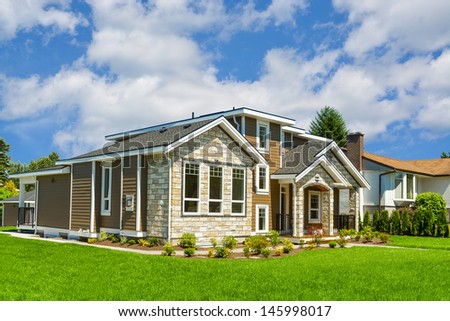 Brand new house. Big luxury house with nicely trimmed and landscaped front yard lawn in the suburbs of Vancouver, Canada.