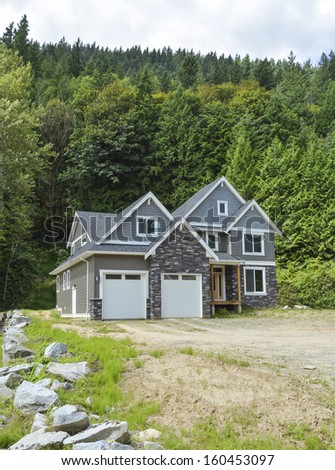 Brand new family house with gravel driveway on country side in British Columbia, Canada.