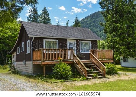 Single house on country side in British Columbia, Canada. Nice house with big patio in front on blue sky background.