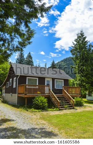 Single house on country side in British Columbia, Canada. Nice house with big patio in front on blue sky background.