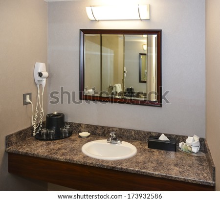 Fragment of a bathroom with mirror and hair drier on a wall